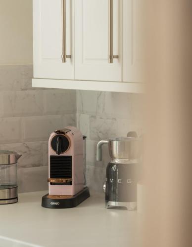 a pink toaster sitting on top of a kitchen counter at Milliners Court - One-Bed Cottage in Central Bath in Bath