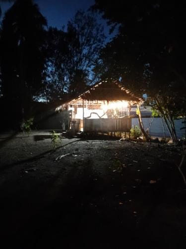 a house with a lit up roof at night at Naviza Homestay in Kepulauan Fam