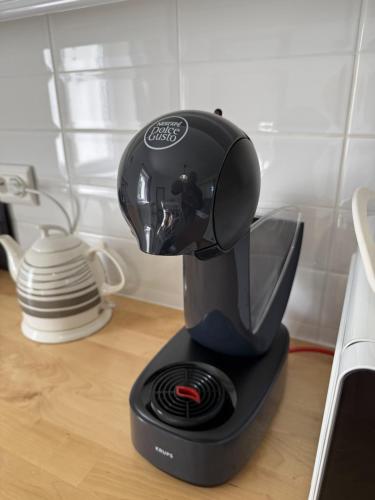 a black coffee maker sitting on top of a counter at Hűvösvölgy Vendégház in Lókút