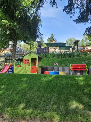 a playground in a yard with a play house at Pension Kaufmann Ferienwohnung "Wolke 7" in Oberwiesenthal