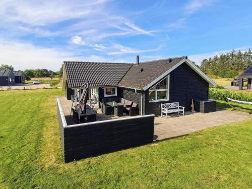 a small black house with a table and a bench at Luxury Lakeside Retreat - By Traum Ferienwohnungen in Ansager