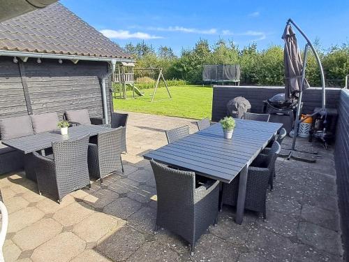 a patio with a table and chairs and an umbrella at 5 star holiday home in Ansager in Ansager