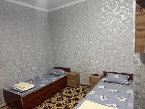 a bedroom with two beds and a wall at Karakalpak Travel in Nukus