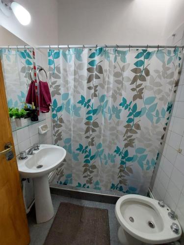 a bathroom with a sink and a shower curtain at Casa El Jacarandá in San Juan