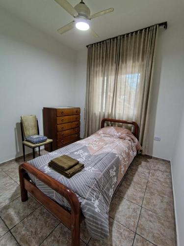 a bedroom with a bed and a dresser and a window at Casa El Jacarandá in San Juan