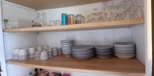 a shelf with plates and glasses on it at Appartement cozy maison Ed Den in Tauves