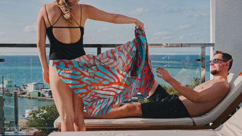 a man and a woman sitting in a chair holding a towel at Arrival Beach and Spa in Gulhi