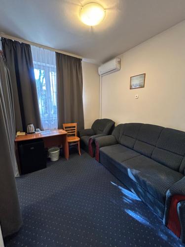 a living room with a couch and a desk at Corvin Hotel in Győr