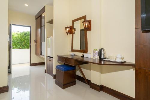 a bathroom with a vanity and a mirror at JR Siam Inn Resort in Kata Beach