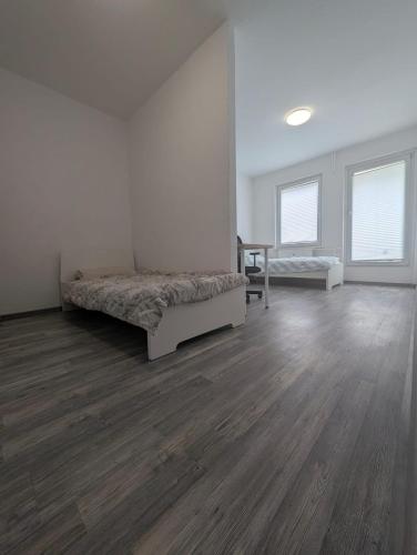 a white room with a bed and a wooden floor at Ihr Premium-Zuhause auf Zeit Komfortabel Wohnen in Bestlage in Hannover