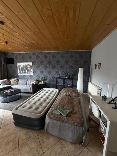 a living room with a large bed and a couch at Idas stuga in Wächtersbach