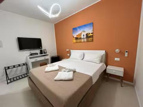 Un dormitorio con una cama grande y un televisor de pantalla plana. en Duecento Rooms, en Palermo