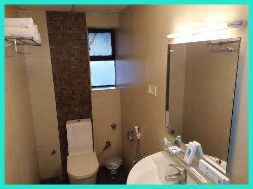 a bathroom with a toilet and a sink and a mirror at HOTEL -THE R & HS PALACE - Near Sea Beach - Shree Jagarnath Temple - Free Wi-Fi Facilities # Fully Air Conditioned Hotel At Prime Location in Puri