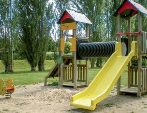 a playground with a slide in a park at Jardin et Étang services gratuits piscine tennis golf in Ivry-la-Bataille