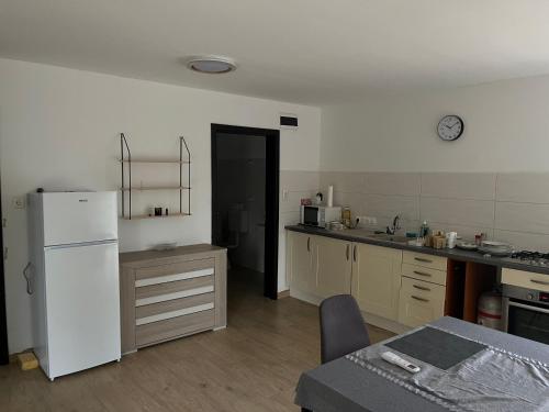 a kitchen with a white refrigerator and a table at Zöldkert Kecskemét in Kecskemét