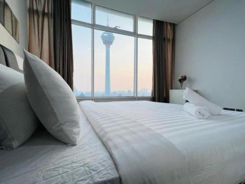 a bedroom with a large bed with a view of a tower at Vortex Residenc klcc serviced apartment near by Bukit Bintang in Kuala Lumpur