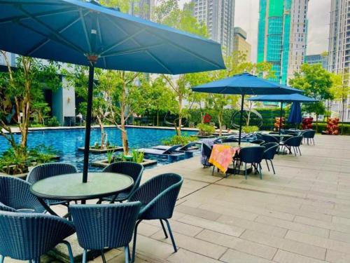 a patio with tables and chairs and blue umbrellas at Vortex Residenc klcc serviced apartment near by Bukit Bintang in Kuala Lumpur