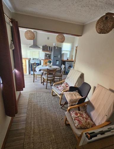 a living room with chairs and a table and a kitchen at Casa equipada y acogedora in Trinidad