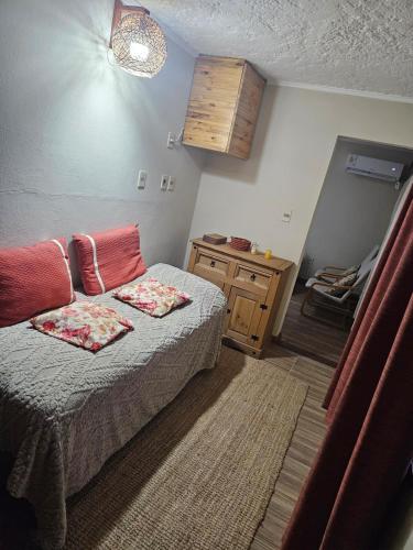Cette chambre comprend un lit avec deux oreillers et une commode. dans l'établissement Casa equipada y acogedora, à Trinidad