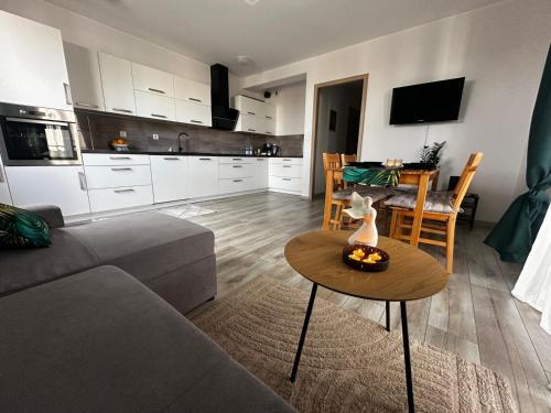 una sala de estar con un sofá y una mesa en Urban Green Września,Przytulny apartament z parkingiem, en Września