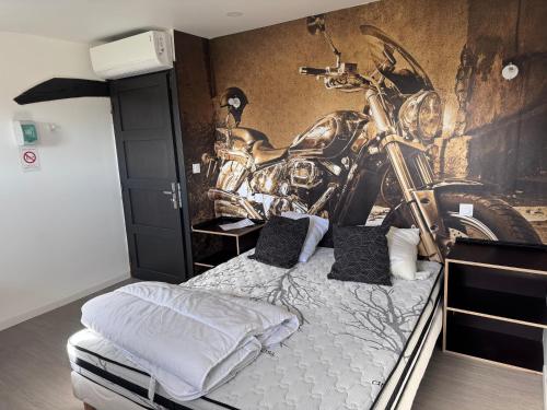 Un dormitorio con un mural de motocicleta en la pared. en dépendance de la Métairie, en Bignan
