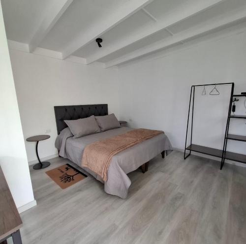 Casa Árbol lodge في بابودو: غرفة نوم بها سرير في غرفة بيضاء