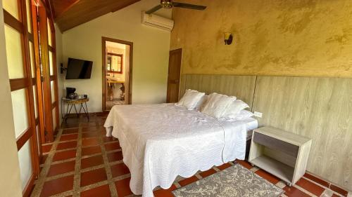 a bedroom with a white bed in a room at Portales del Tayrona Garden Hotel in Calabazo