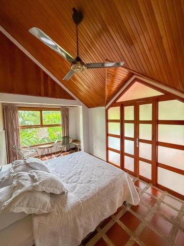 a bedroom with a ceiling fan and a bed at Portales del Tayrona Garden Hotel in Calabazo