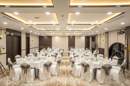 a banquet hall with white tables and chairs at Iconique Hotel Nha Trang in Nha Trang
