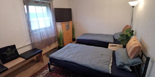 a small room with two beds and a window at Ganzes Ferienhaus mit Garten, 1000qm umzäuntes Grundstück, mit privater Küche, Bad, 4 Schlafzimmer, 8 Betten, Free WiFi, Top Lage in Kassel, so privat wie zu Hause, ideal für Familien mit Kinder in Kassel