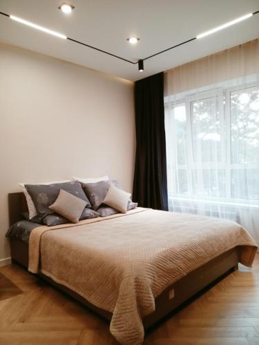 a bedroom with a large bed and a window at Комфортная квартира в центре города in Almaty