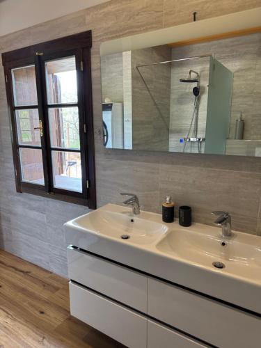 a bathroom with two sinks and a mirror at Slunečná roubenka u splavu 