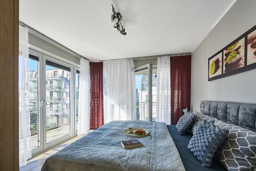 a bedroom with a bed and a large window at Four Seasons Aquamarina in Świnoujście