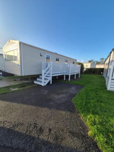 a large white mobile home with a porch at Meadow Banks Combe Haven in Hastings