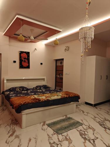 a bedroom with a bed and a chandelier at Utsava Homestay in Chitradurga