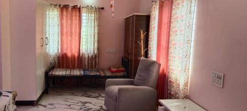 a living room with a chair and a window at Utsava Homestay in Chitradurga