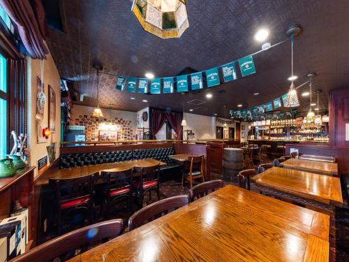 um restaurante com mesas e cadeiras de madeira e um bar em APA Hotel Nagasaki Ekimae em Nagasaki