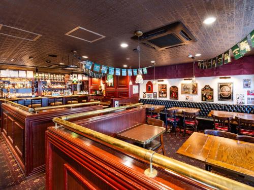 um bar com mesas e cadeiras num quarto em APA Hotel Nagasaki Ekimae em Nagasaki