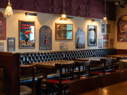 um restaurante com mesas e cadeiras e cartazes na parede em APA Hotel Nagasaki Ekimae em Nagasaki