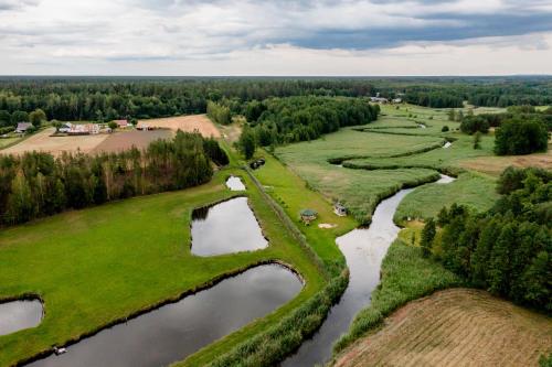 an aerial view of a golf course with a river at Rodzinne wczasy nad Czarną Hańczą 