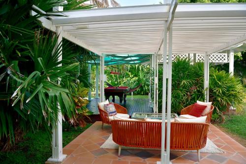 a pergola with chairs and a table on a patio at HOTEL CASA AMARILLA et RESTAURANT in Punta Chame