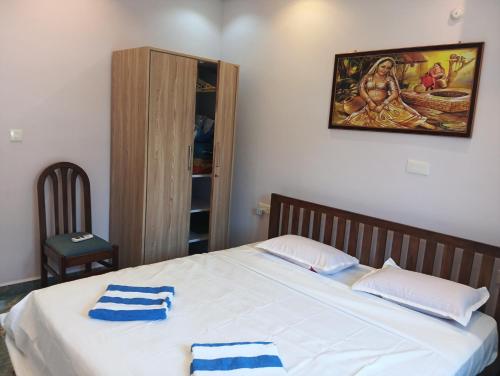 a bedroom with a bed with two towels on it at Plams Beach comfort in Benaulim