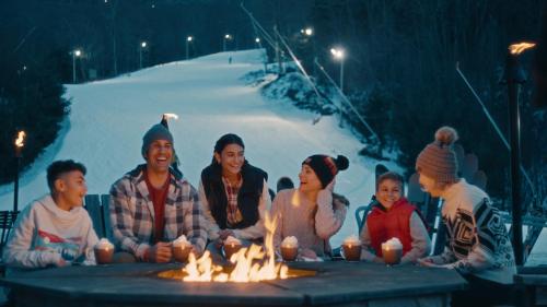 a group of people sitting around a table with lit candles at Camelback Resort in Tannersville