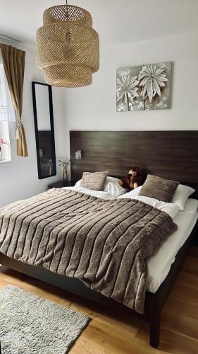 a bedroom with a large bed with a teddy bear on it at Donovaly Apartman Galileo in Donovaly