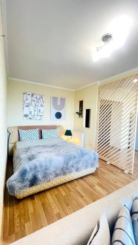 a bedroom with a large bed with a blue blanket at Затишна красива студія в новобудові з балконом in Chernivtsi