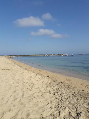 a beach with footprints in the sand and the water at Domu de Palla- IUN-E5167 in Bauladu