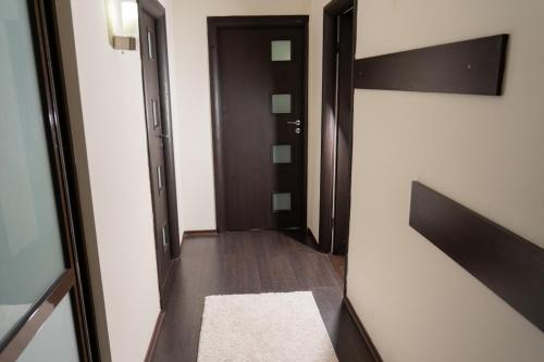 a hallway with a door and a rug at Casa M&R in Bucharest