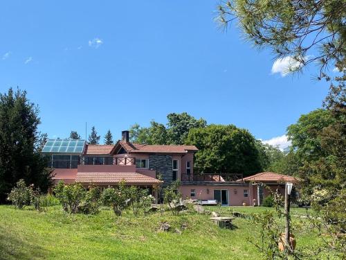 a house with solar panels on top of a field at Tu Casa de Campo - Confort, Hogar & Naturaleza in Estancia Grande