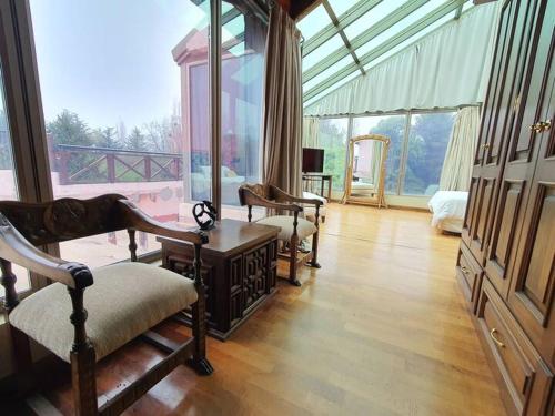 a living room with furniture and a large window at Tu Casa de Campo - Confort, Hogar & Naturaleza in Estancia Grande