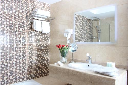 a bathroom with a sink and a mirror at Sandy Palace Hotel Amman in Amman